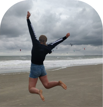 Meisje die op het zand springt
